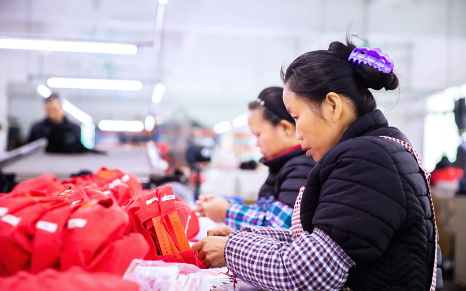 Workers handling headwear on the StarCap production floor