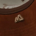 Brown suede visor underside with custom flat and 3D embroidery