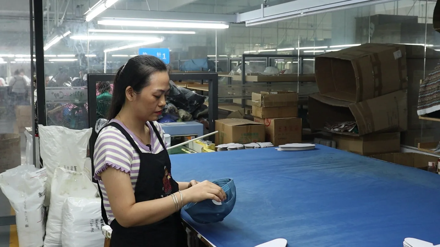 MasterCap staff member checking the interior construction of a physical cap sample