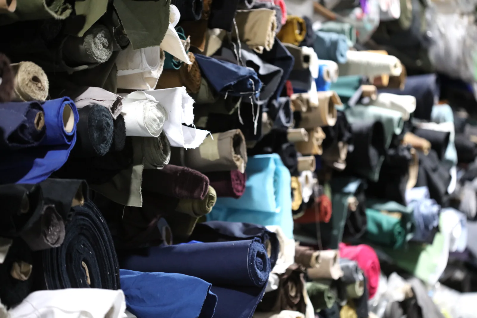 Assorted fabric rolls in different colors prepared for custom cap development
